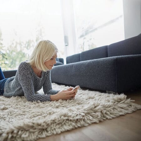 Woman laying on rug and wood floor