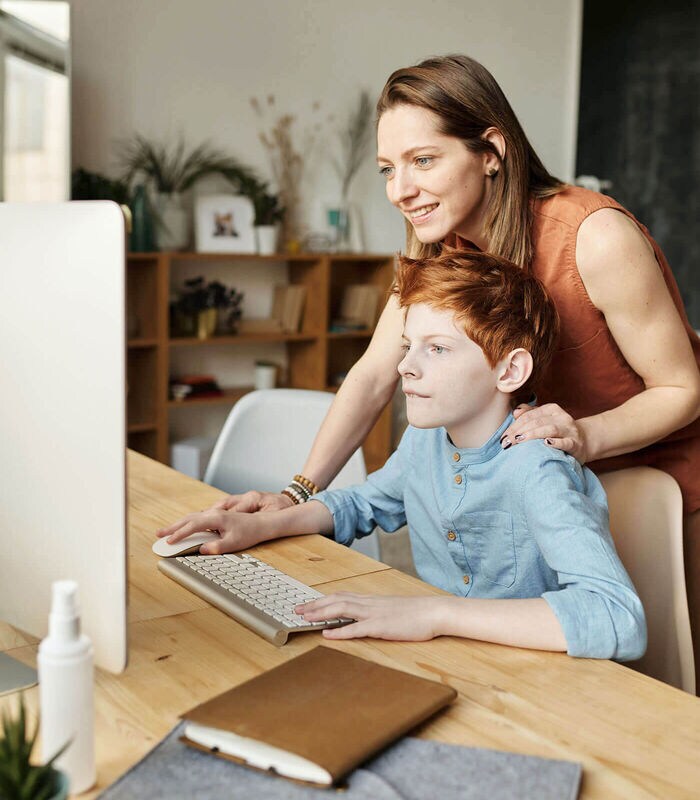 Adult helping child on the computer